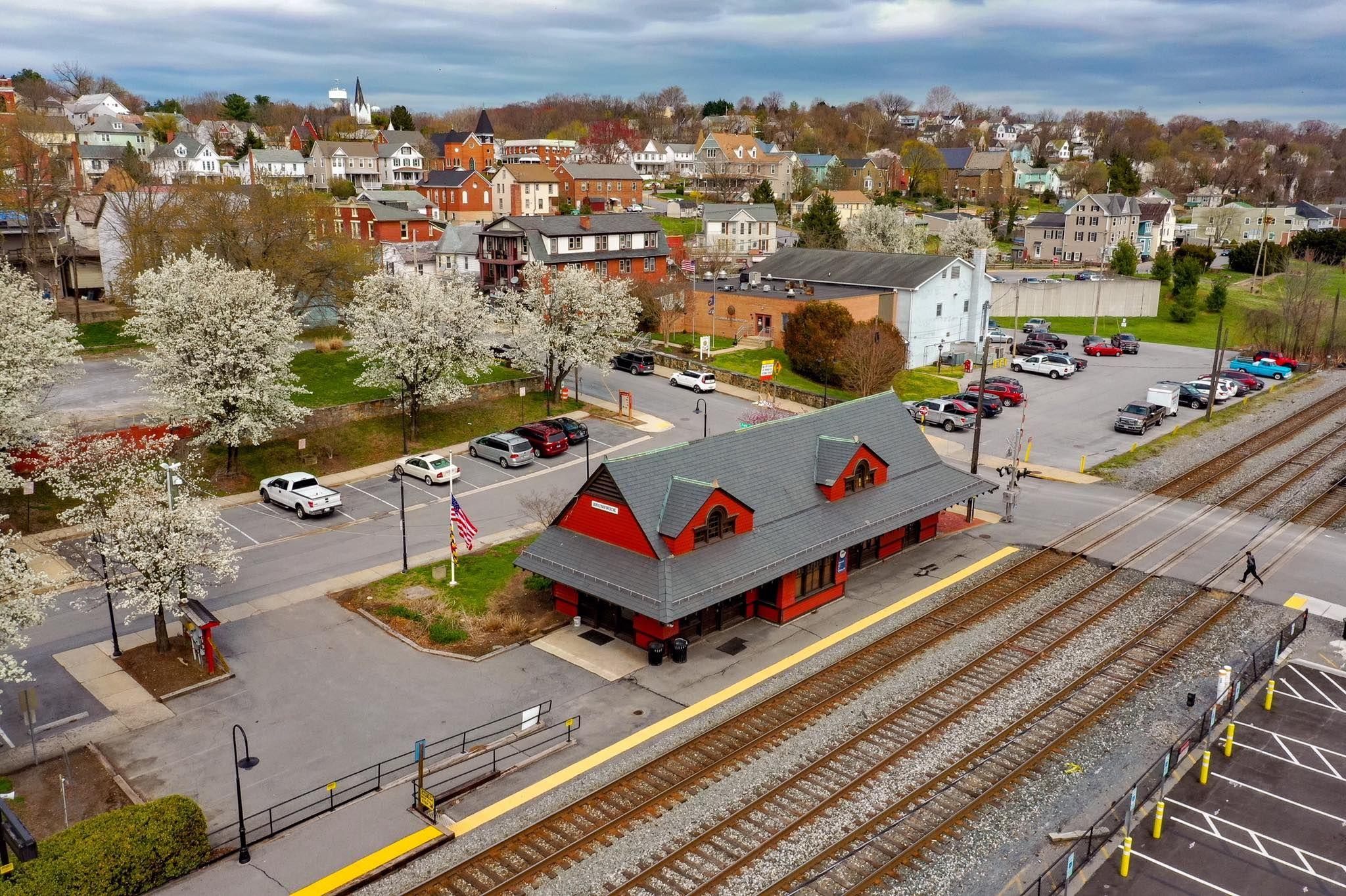 Brunswick, MD Real Estate Aerial view of the historic Brunswick, MD train depot, with its red roof, station platform, and the town on the hillside behind